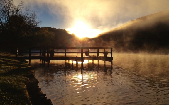 The dock at Lake Austin as the sun sets behind the mountains
