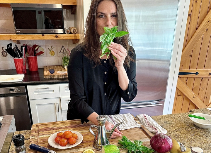 Chef Rita standing with ingredients for her dish displayed on the table