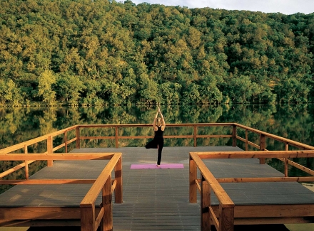 A woman does yoga as the sunrises on a dock over Lake Austin.